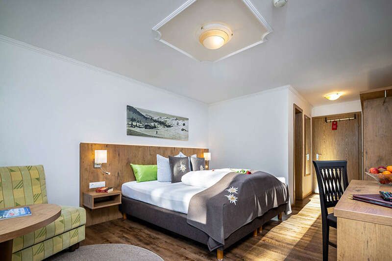 Doppelbett mit Schlafsessel im Zimmer vom Hotel Schlossberg